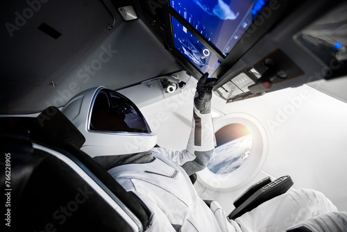 Astronaut on a spaceship flying in outer space. Elements of this image furnished by NASA. photo