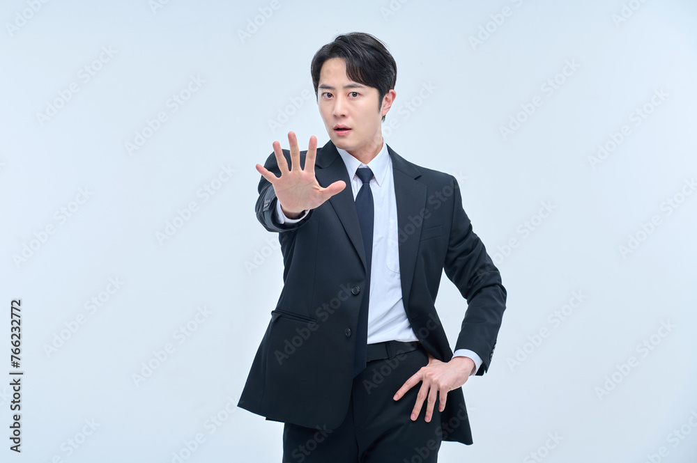 A young office worker man in a navy suit is posing with various facial expressions. A young office worker man in a navy suit is posing with various facial expressions.