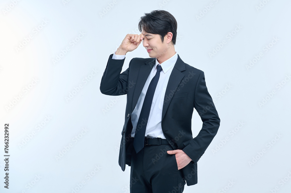 A young office worker man in a navy suit is posing with various facial expressions. A young office worker man in a navy suit is posing with various facial expressions.