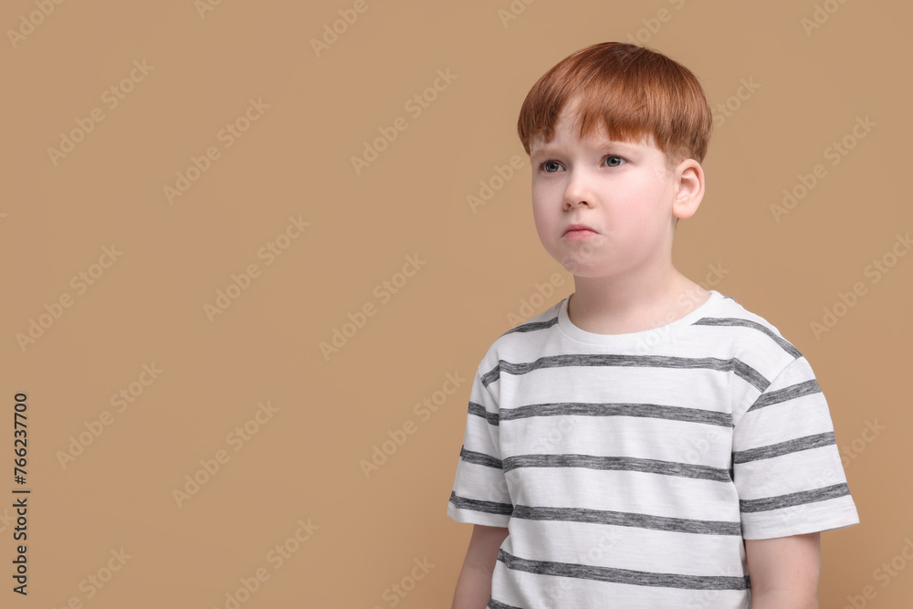 Portrait of sad little boy on beige background, space for text Portrait of sad little boy on beige background, space for text