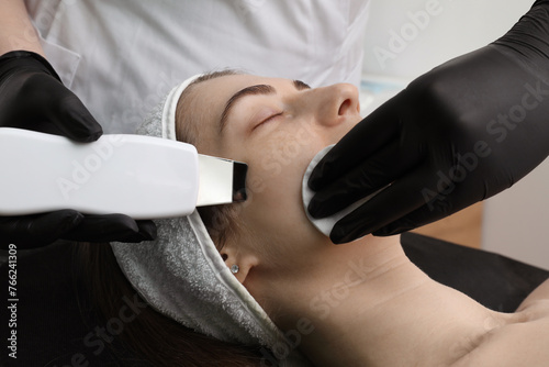 Cosmetologist using ultrasonic scrubber, closeup. Client having cleansing procedure indoors