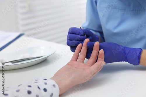 Laboratory testing. Doctor taking blood sample from patient at white table in hospital, closeup