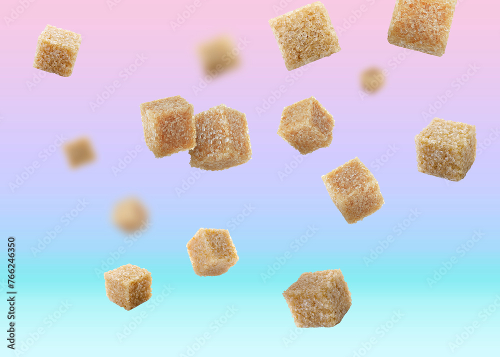 Brown cane sugar cubes falling on color gradient background Brown cane sugar cubes falling on color gradient background