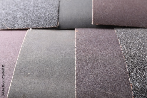 Many sheets of sandpaper as background, closeup photo