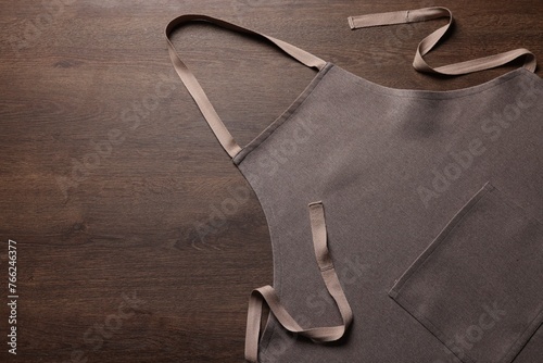 Quadro su tela Stylish brown apron on wooden table, top view. Mockup for design