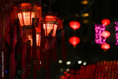Title: A Night of Illumination

Description: Lanterns glow vibrantly against a mesmerizing backdrop of lights, creating an enchanting night scene. photo