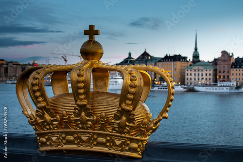 Golden crown on Skeppsholmen bridge in Stockholm, Sweden on summer sunset photo