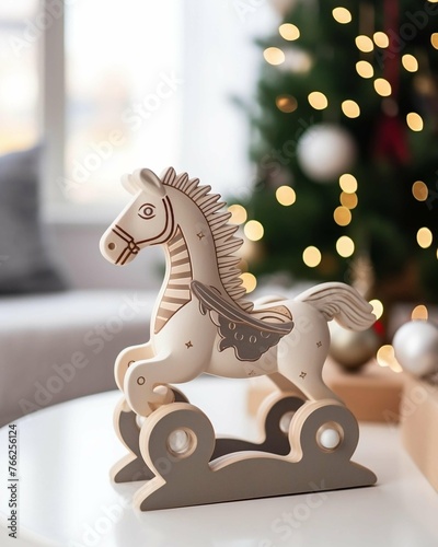 Small wooden toy horse on table in front of Christmas tree
