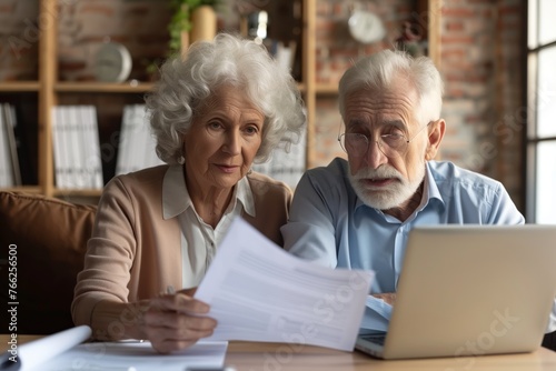 Elderly couple, old lady and man sitting together with a laptop and documents, discussing pension retirement plans, insurance, financial planning or vacation for seniors. 