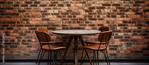 A close-up view of a table with four chairs placed in front of a textured brick wall