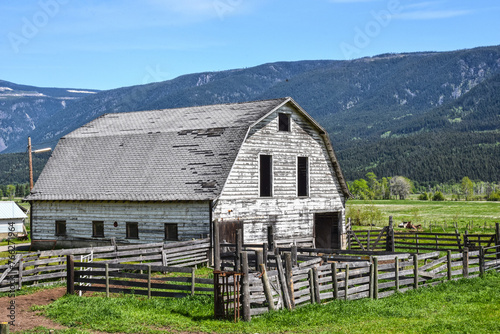Old wooden white barn under blue sky, Canada
