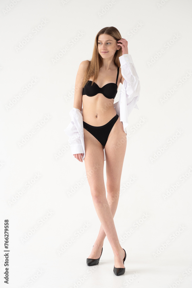 Snap Models. Full length portrait of a beautiful brunette woman in black bikini isolated on white background Snap Models. Full length portrait of a beautiful brunette woman in black bikini isolated on white background