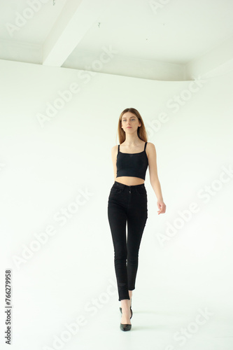 Snap Models. Full length portrait of a beautiful brunette woman in black bikini isolated on white background © alipko