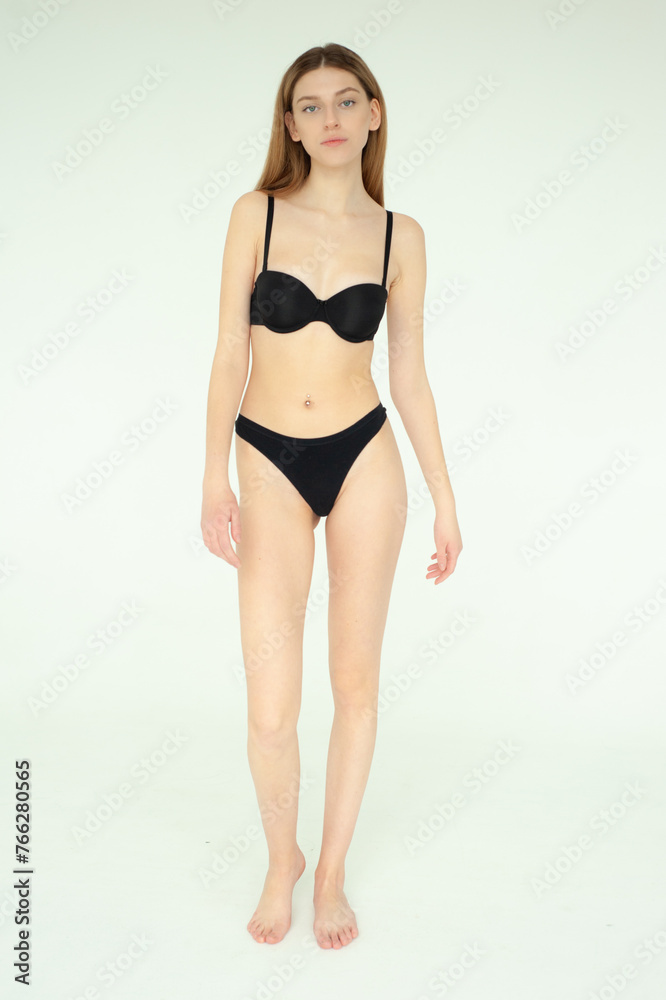 Snap Models. Full length portrait of a beautiful young woman in black bikini isolated on white background Snap Models. Full length portrait of a beautiful young woman in black bikini isolated on white background