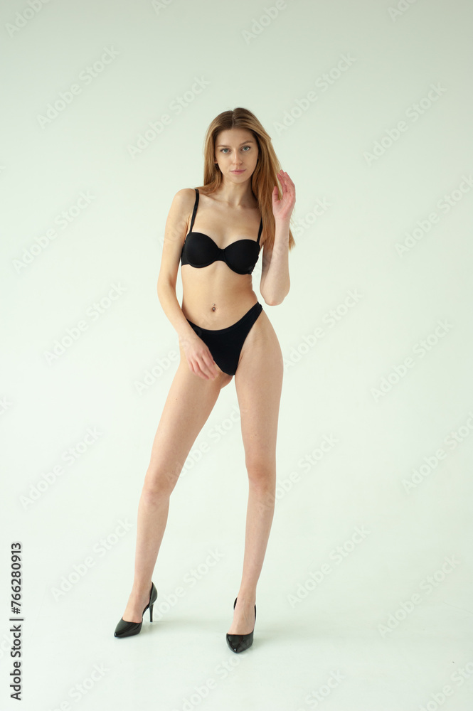 Fototapeta premium Model test portrait with young beautiful fashion model posing on grey background.