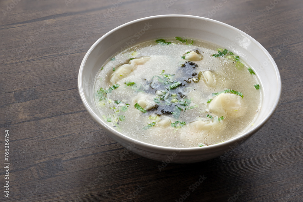 A bowl of shrimp wontons, sprinkled with seaweed and dried shrimps, traditional Chinese breakfast A bowl of shrimp wontons, sprinkled with seaweed and dried shrimps, traditional Chinese breakfast