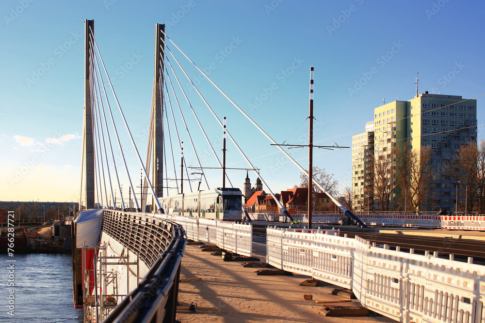 Obraz premium New bridge spans Elbe river in Magdeburg with a tram crossing it