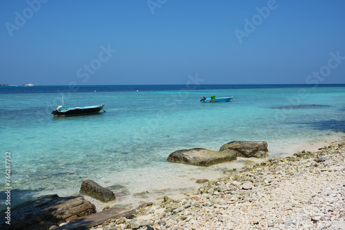 Beautiful afternoon beach scene of Rasdhoo. It is an inhabited island of the Maldives. The beach scene with boat floating on it. © peacefoo