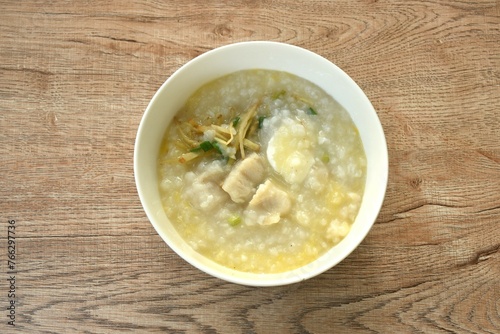 rice porridge with bass fish and boiled egg topping ginger on bowl 