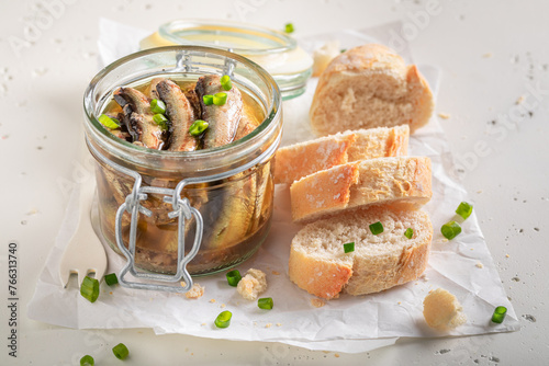 Healthy and canned smoked sprats on white food paper.