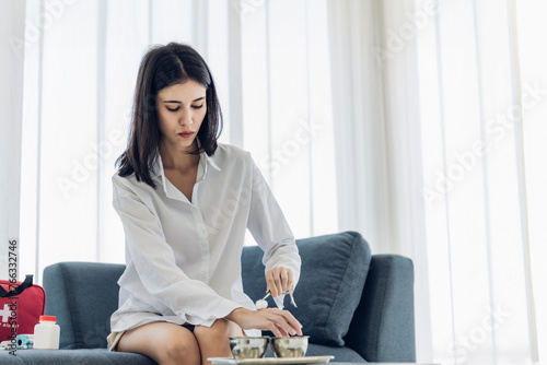 Woman Self healing perform first aid injury after she has been an accident. Woman cleaning wound with cotton ball and dressing set, wound care process