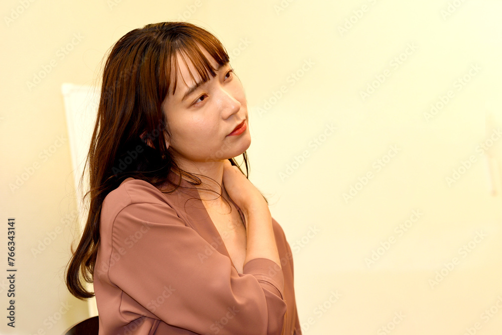 肩こりに悩む怠そうな若いアジア人女性 肩こりに悩む怠そうな若いアジア人女性
