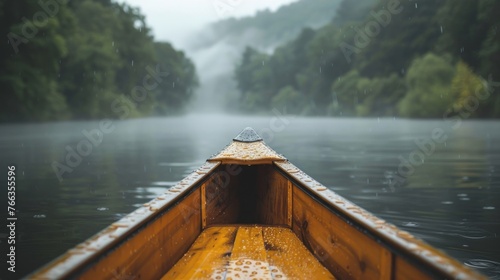 Rainy Canoe Journey on a Misty Forest Lake Gentle rain falls upon a wooden canoe, navigating through the misty embrace of a serene forest-lined lake. © nitiroj