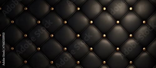 Detailed view of a dark leather wall adorned with shiny gold studs for an elegant and sophisticated decor © TheWaterMeloonProjec