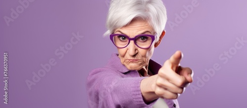 An elderly woman with violet glasses gestures towards the camera with her thumb and finger, showcasing the importance of vision care