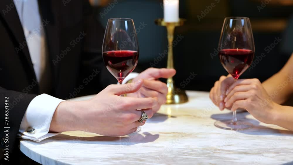 Man and woman holding hands while sitting at the table in the restaurant, cropped, close up. Lifestyle, love, relationships concept. Slow motion Man and woman holding hands while sitting at the table in the restaurant, cropped, close up. Lifestyle, love, relationships concept. Slow motion