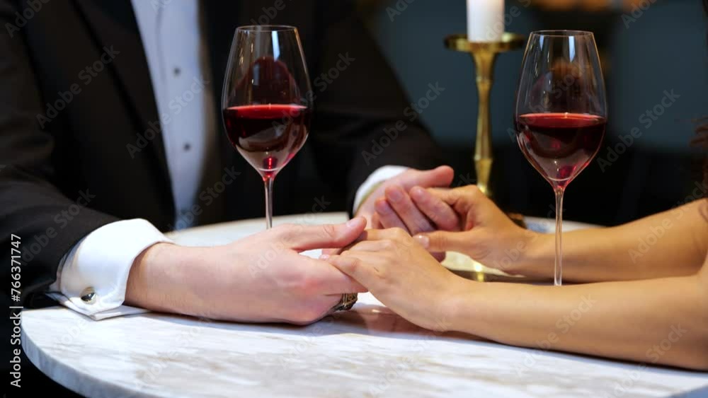 Man touching female hands while having romantic dinner in the restaurant, cropped, close up. Lifestyle, love, relationships concept. Slow motion Man touching female hands while having romantic dinner in the restaurant, cropped, close up. Lifestyle, love, relationships concept. Slow motion