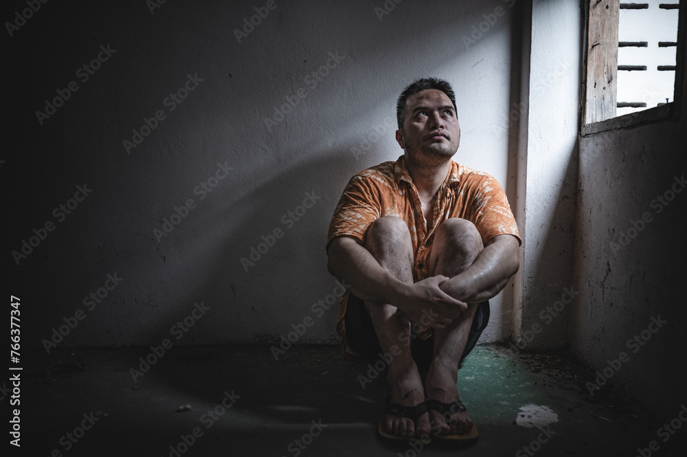 Asian man addict drug in the deserted place,A junkie feels alone in this world,Sad young man sitting in the corner of the room,People are stressed and have depression