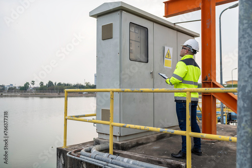 Electrical engineer man checking voltage at the Power Distribution Cabinet,preventive maintenance Yearly,Supervisor Working at a wastewater treatment plant