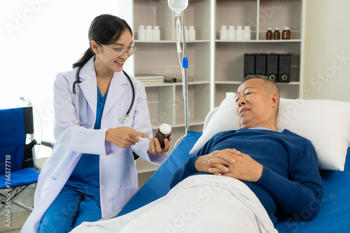 An old man hospitalized lies in bed while a doctor checks his pulse. Doctor or nurse examining a senior male patient  caring for and encouraging him in the hospital room  lying on the bed.