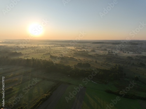 Łąki o brzasku, poranek w zamglonej zielonej okolicy, pastwiska oraz łąki o poranku, wschód słońca nad mokradłami, 