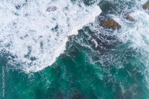 Aerial drone top down view bird eye view of sea waves breaking on rocks