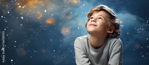 A young kid with curious eyes staring up at the vast blue sky above in wonder and amazement © TheWaterMeloonProjec