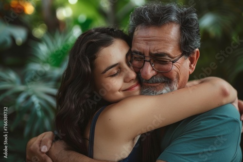 middle-aged father hugging his teenage daughter . Father’s day