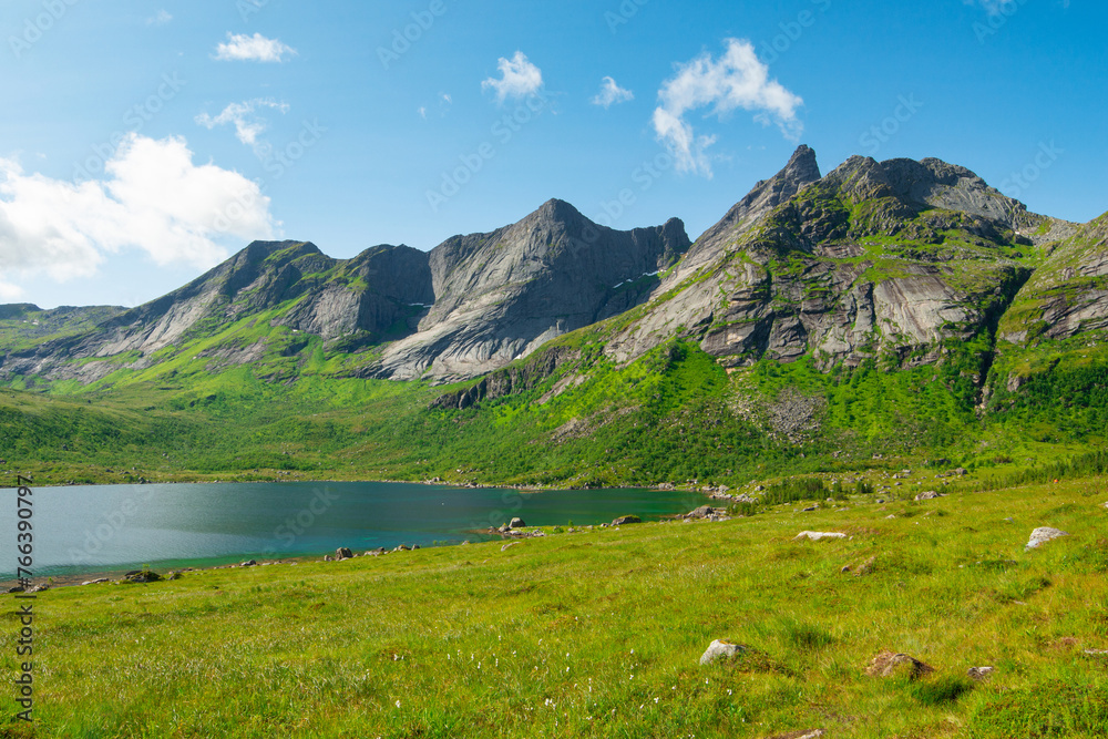 Mountain lakes in Lofoten islands, Nordland, Norway. Alpine lake surrounded by the scenic nature with fields and peaks. Hiking in wild nature of Lofoten islands.