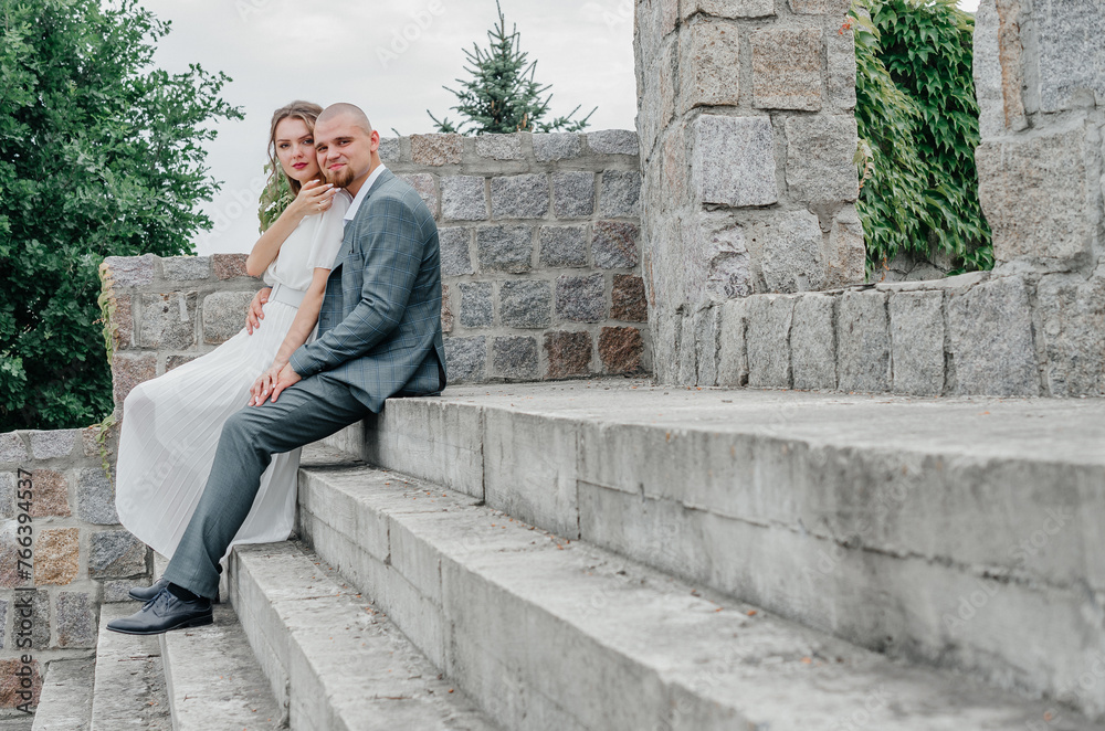 the bride and groom are sitting on the stairs the bride and groom are sitting on the stairs