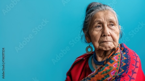 Mature Native American Woman’s Contemplative Look on Blue © Ananncee Media