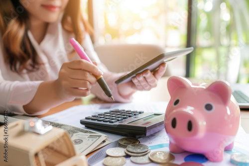 Women calculate expenses with calculator and piggy bank. Tax time, finance, investment and savings concept photo