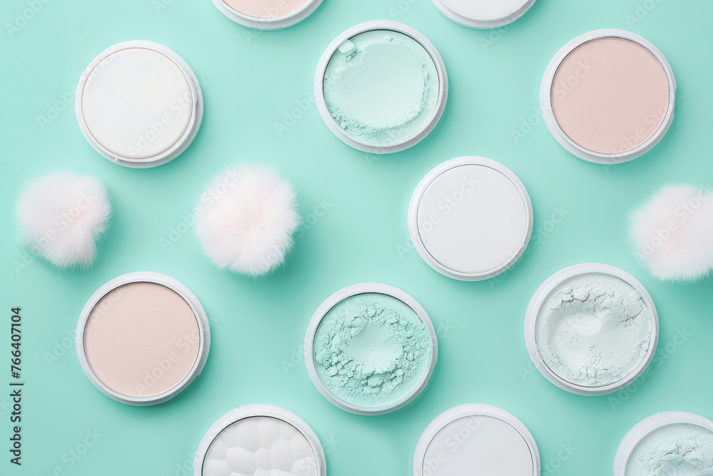 top view of cosmetic powders and puff applicators on turquoise surface top view of cosmetic powders and puff applicators on turquoise surface