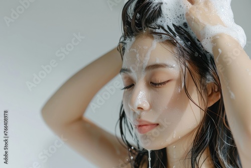 Beautiful woman washing his hair on white background photo