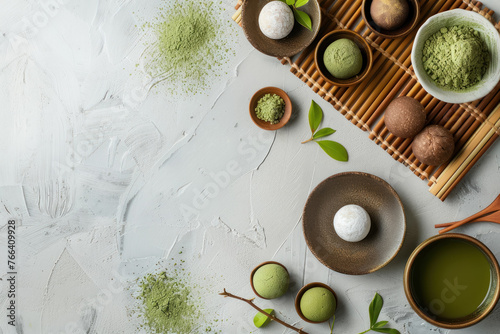 matcha themed japanese dessert spread with mochi, tea, and powder on textured surface