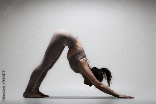 Beautiful caucasian woman in yoga pose. Half silhouette shot of a girl making stretching exercises.