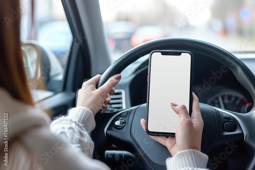 person Driver holding phone white screen on steering wheel background © Igor