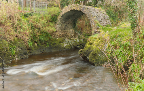 Ancient arched bridge over a fast flowing river