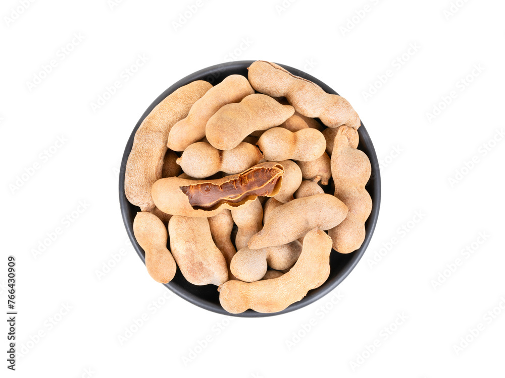 Black bowl full of tamarind fruits in shell isolated on white background, top view