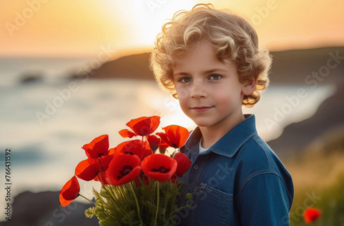 A smiling curly-haired blond boy with a bouquet of red poppies in his hands against the backdrop of a poppy field and the ocean in the sunlight. flower for Remembrance Day, Memorial Day, Anzac Day 